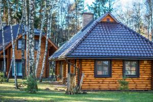 una cabaña de madera con chimenea encima en Meguva Resort Hotel, en Palanga