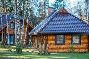 a log cabin with a chimney on top of it at Meguva Resort Hotel in Palanga