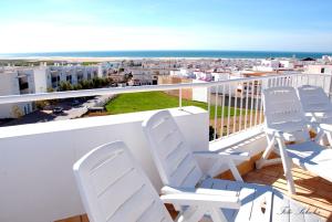 Un balcón con sillas y vistas al océano. en Hostal Al-Andalus, en Conil de la Frontera