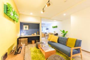 a living room with a blue couch and a fireplace at ORIGAMI STAY in Nagoya