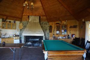 a kitchen with a pool table and a fireplace at Cabañas Cerro Huemules in Coihaique