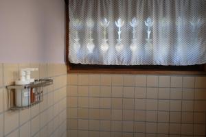 a bathroom with a window with a shower curtain at Paiyannoi Guesthome in Chiang Mai