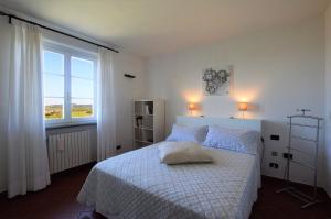 a bedroom with a bed with blue pillows and a window at La Casa di Chloe in Poggibonsi