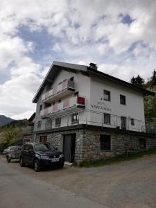 un gran edificio blanco con coches estacionados frente a él en Apart Alpinea, en Landeck