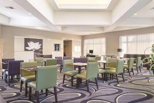 een grote wachtkamer met tafels en stoelen bij La Quinta Inn & Suites by Wyndham Ontario Airport in Ontario