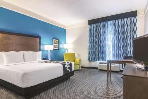 オーランドにあるLa Quinta by Wyndham Orlando UCFのベッドとテレビがあるホテルの部屋