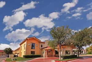 a building on a street with a cloudy sky at La Quinta Inn by Wyndham Amarillo Mid-City in Amarillo