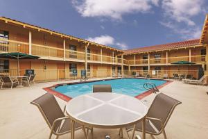 a patio with a table and chairs and a pool at La Quinta Inn by Wyndham Midland in Midland