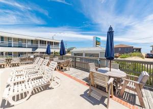 a group of tables and chairs with blue umbrellas at Saltaire Cottages in Kitty Hawk Beach
