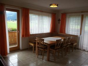jadalnia ze stołem i krzesłami oraz oknem w obiekcie Apparthotel Stoanerhof w mieście Uderns +27 zdjęć