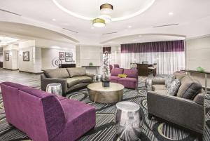 a hotel lobby with purple furniture and a table at La Quinta Inn & Suites by Wyndham San Antonio Riverwalk in San Antonio