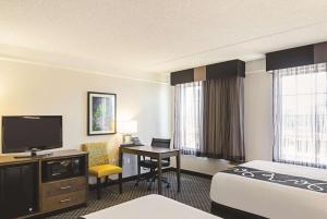 a hotel room with a bed and a desk with a television at La Quinta Inn & Suites by Wyndham San Antonio Riverwalk in San Antonio +36 photos
