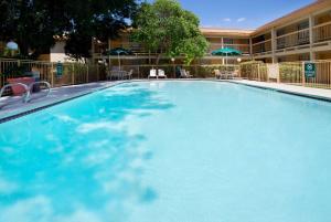 a large blue swimming pool in front of a hotel at La Quinta Inn by Wyndham Austin Oltorf in Austin