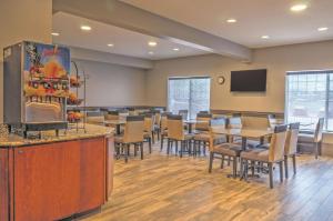 un restaurante con mesas y sillas y TV de pantalla plana en Best Western Plus Kalispell/Glacier Park West Hotel & Suites, en Kalispell