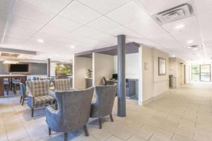 a lobby with chairs and a table and a kitchen at La Quinta Inn & Suites by Wyndham Jackson Airport - Pearl in Pearl