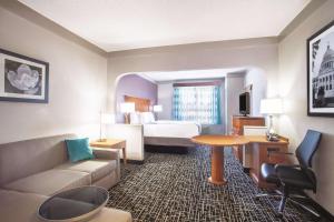 a hotel room with a bed and a couch and a table at La Quinta Inn & Suites by Wyndham Jackson Airport - Pearl in Pearl +18 photos