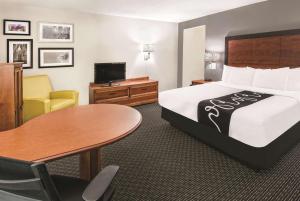 a hotel room with a bed and a table at La Quinta Inn & Suites by Wyndham San Antonio Riverwalk in San Antonio