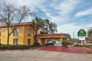 a hotel with a sign in front of a building at La Quinta Inn by Wyndham Savannah Midtown in Savannah