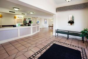 a lobby of a hospital with a woman standing at a counter at La Quinta Inn by Wyndham Austin Oltorf in Austin