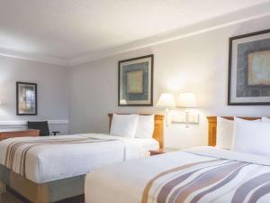 una camera d'albergo con due letti e due lampade di La Quinta Inn by Wyndham New Orleans West Bank / Gretna a Gretna