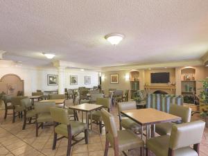 a restaurant with tables and chairs and a fireplace at La Quinta Inn by Wyndham San Diego Chula Vista in Chula Vista