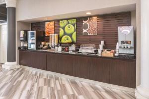 a restaurant with a counter with a food counter at La Quinta by Wyndham St. Louis Westport in Saint Louis