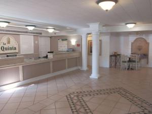 a lobby of a hospital with a counter and columns at La Quinta Inn by Wyndham Bakersfield South in Bakersfield