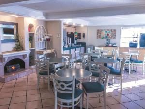 a restaurant with tables and chairs and a fireplace at La Quinta Inn by Wyndham Moline Airport in Moline