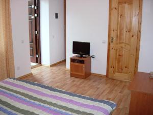 a room with a bed and a television on a table at Meerim Murok in Bosteri