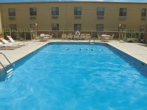 a large blue swimming pool in front of a hotel at La Quinta Inn by Wyndham Moline Airport in Moline
