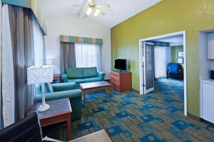 a living room with a couch and a tv at La Quinta Inn by Wyndham Amarillo West Medical Center in Amarillo