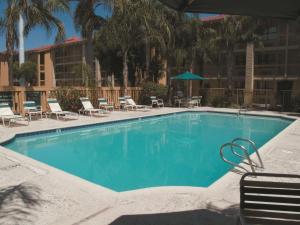 een groot zwembad met stoelen en een hotel bij La Quinta Inn by Wyndham Bakersfield South in Bakersfield