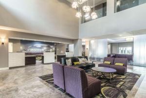 een lobby met een bank, stoelen en een tafel bij La Quinta by Wyndham Arlington North 6 Flags Dr in Arlington