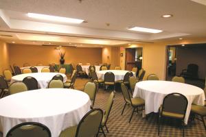 La Quinta by Wyndham Oakland - Hayward في هايوارد: قاعة اجتماعات مع طاولات وكراسي بيضاء