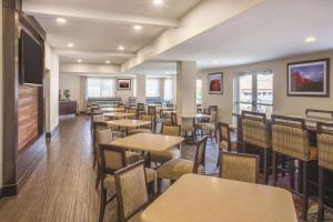 a dining room with tables and chairs and a flat screen tv at La Quinta by Wyndham Moab in Moab