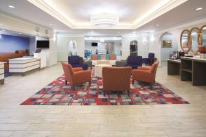 a lobby with a waiting room with chairs and tables at La Quinta by Wyndham Gallup in Gallup