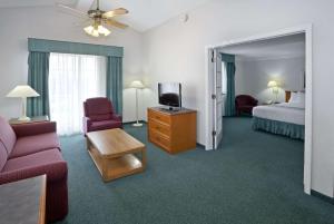 a hotel room with a bed and a couch and a tv at La Quinta Inn by Wyndham Omaha West in Omaha