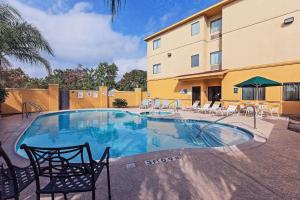 a large swimming pool with chairs and a building at La Quinta by Wyndham Pasadena in Pasadena