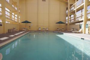 uma grande piscina num edifício com mesas e guarda-sóis em La Quinta Inn by Wyndham Albuquerque Airport em Albuquerque