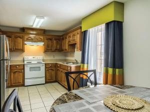 a small kitchen with wooden cabinets and a table with a tableablish at La Quinta by Wyndham Prattville in Prattville