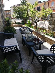 a patio with three chairs and a table with a lantern at Il Giardino in Baunei