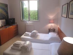a bedroom with two beds and a window with towels at Appartamenti Boboli in Punta Ala