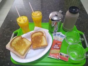 una bandeja verde con un plato de tostadas y dos bebidas en MOTEL RED LOVE, en Belo Horizonte