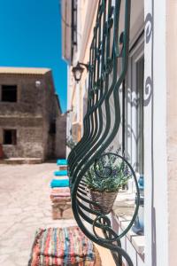 a bench on the side of a building with a potted plant at Spiti Lagis in Chlomatianá