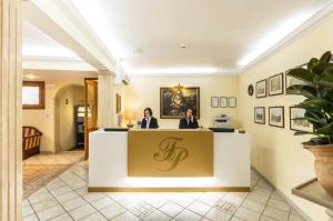 Dos mujeres sentadas en una recepción en el vestíbulo de un hotel en Hotel Tempio Di Pallade en Roma