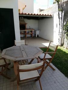 a wooden table and two chairs on a patio at Moradia São Pedro in Porto Santo