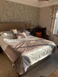 a bedroom with a large bed and a large window at Lurgan West Lodge in Randalstown