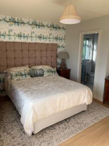a bedroom with a large bed with a large headboard at Lurgan West Lodge in Randalstown