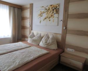 1 dormitorio con 1 cama con sábanas y almohadas blancas en Haus Bader, en Ehrwald