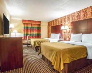 um quarto de hotel com duas camas e uma televisão em Days Inn by Wyndham Jersey City em Jersey City